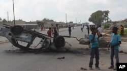 FILE - A burnt out vehicle lays on its roof in Lusaka, Zambia, April 7, 2016. On Wednesday police arrested more than 250 people for allegedly attacking foreign nationals and looting their stores.