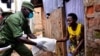 FILE - A civilian gets food during a government distribution exercise to civilians affected by the lockdown, as part of measures to prevent the potential spread of coronavirus disease (COVID-19), in Kampala, Uganda, April 4, 2020.