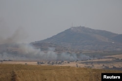 FILE - Smoke rises over Golan Heights as it's seen from Deraa area, Syria July 6, 2018.