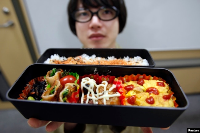 An employee of an Internet company, paperboy&co., shows his homemade boxed lunch during a lunch break in Tokyo April 15, 2009. (REUTERS/Yuriko Nakao)