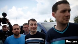 OSCE observers stand on a road 30 km (19 miles) from Donetsk in eastern Ukraine, May 3, 2014, after being freed. 