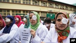 Kashmiri doctors and medical workers wear bandages on their eyes as a mark of protest against the use of pellet guns and recent killings in Srinagar, Indian-controlled Kashmir, Wednesday, Aug. 10, 2016. 