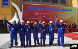 FILE - Chinese workers pose at the inauguration site of a train linking Addis Ababa to Djibouti, 20 kilometres (13 miles) from the center of Addis Ababa, Ethiopia, Oct. 5, 2016.