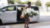 File: A visitor arrives with a wreath at the Singapore Casket funeral parlor building where the body of the late former president of Zimbabwe is being held on Saturday, Sept. 7, 2019, in Singapore. Robert Mugabe, the former leader of Zimbabwe forced to resign in 2017