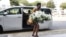 File: A visitor arrives with a wreath at the Singapore Casket funeral parlor building where the body of the late former president of Zimbabwe is being held on Saturday, Sept. 7, 2019, in Singapore. Robert Mugabe, the former leader of Zimbabwe forced to resign in 2017