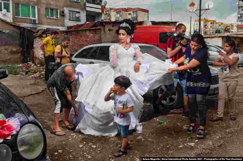 На фотоснимке – невеста, которая готовится к свадьбе на улицах цыганского района в болгарском Пловдиве. Район Столипиново, где был сделан снимок, является самым густонаселенной общиной рома в Европе: здесь проживают около 40 тысяч человек. 📸: Selene Magnolia / Siena International Photo Awards 