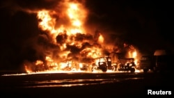 A NATO supply convoy burns after it was attacked in Hub, near Karachi, Pakistan, Sept. 15, 2013.