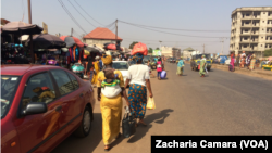 Des femmes quittant un marché de la banlieue de Conakry, le 17 janvier 2018. (VOA/Zacharia Camara)