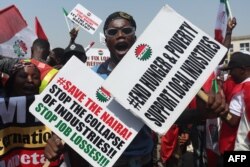 FILE —A protestor holds placards during a protest in Abuja on February 27, 2024.