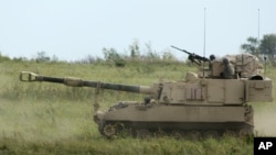 资料照：美国陆军2012年9月12日在堪萨斯举行的军事训练中使用帕拉丁自行榴弹炮系统。