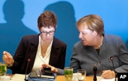 FILE - German Chancellor and chairwoman of the German Christian Democratic Union (CDU), Angela Merkel, right, and Annegret Kramp-Karrenbauer, left, secretary general of the CDU, talk at meeting in Berlin, Germany, Nov. 4, 2018.