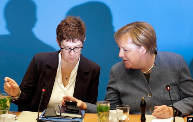 FILE - German Chancellor and chairwoman of the German Christian Democratic Union (CDU), Angela Merkel, right, and Annegret Kramp-Karrenbauer, left, secretary general of the CDU, talk at meeting in Berlin, Germany, Nov. 4, 2018.