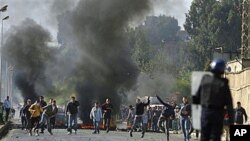 Youths clash with police officers in the El Harrache district of Algiers after prices were increased on basic food staples, Jan 6, 2011