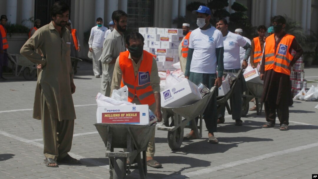 Para relawan membagikan bantuan bahan pangan kepada fakir miskin saat penerapan lockdown Covid-19 pada bulan Ramadan di Peshawar, Pakistan (4/5).