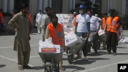 Volunteers deliver food relief packages for the Muslim fasting month of Ramadan, during a government-imposed nationwide lockdown to help contain the spread of the new coronavirus, in Peshawar, Pakistan, May 4, 2020.