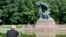 A tourist sits by the Chopin monument in Lazienki park in Warsaw, Poland, Sept. 3, 2018.