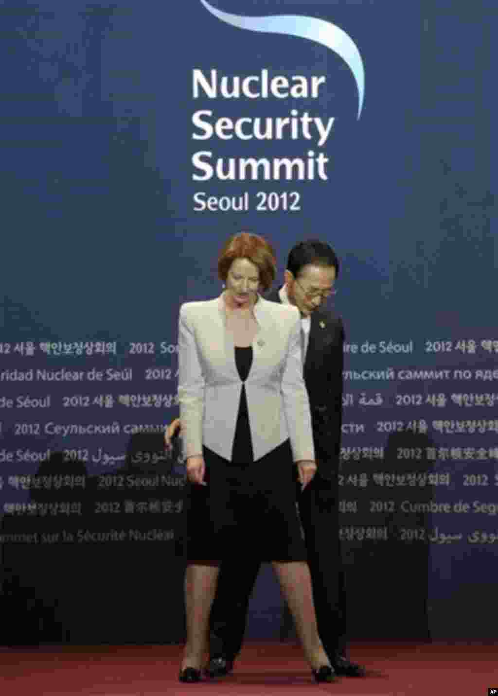 South Korean President Lee Myung-bak changes places with Australian Prime Minister Julia Gillard during a welcome ceremony for the Nuclear Security Summit at the Coex Center, in Seoul, South Korea, Monday, March 26, 2012. (AP Photo/Susan Walsh)
