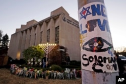 FILE - A menorah is tested outside the Tree of Life Synagogue in preparation for a celebration service at sundown on the first night of Hanukkah, Sunday, Dec. 2, 2018 in the Squirrel Hill neighborhood of Pittsburgh. (AP Photo/Gene J. Puskar, File)