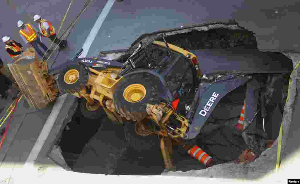 A construction vehicle lies where it was swallowed by a sinkhole on Saint-Catherine Street in downtown Montreal, Canada, Aug. 5, 2013.