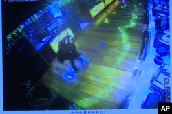 This image taken from TV of CCTV video shows a gunman firing a weapon into the air inside a casino in the Resorts World Manila complex before starting fires and firing on security forces, June 2, 2017. Philippine police say the attacker was a tall, English-speaking man with a mustache.