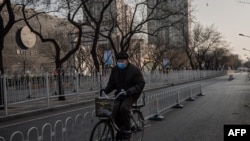 一月29日，一名男子在空盪盪的武漢街頭騎自行車。