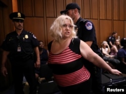 Police remove a protester during U.S. Supreme Court nominee judge Brett Kavanaugh's Senate Judiciary Committee confirmation hearing on Capitol Hill in Washington, Sept. 5, 2018.