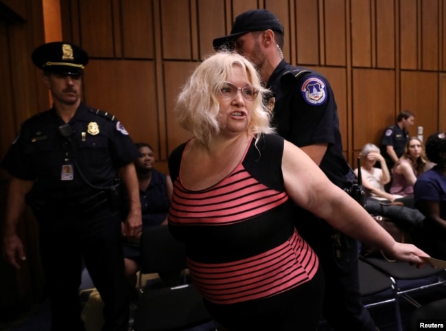 Police remove a protester during U.S. Supreme Court nominee judge Brett Kavanaugh's Senate Judiciary Committee confirmation hearing on Capitol Hill in Washington, Sept. 5, 2018.