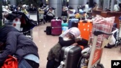 ژماره‌یه‌ک هاوڵاتی بیانی له‌ فڕۆکه‌خانه‌ی قاهیره‌ چاوه‌ڕێی فڕۆکه‌یه‌ک ده‌که‌ن له‌ میسر ده‌ریان بکات، شه‌ممه‌ 29 ی یه‌کی 2011