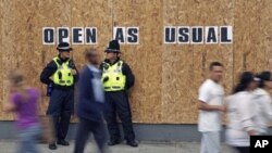 Police officers from Wales patrol outside a boarded up shop in Streatham, south London, August 10, 2011
