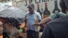 Red Cross worker Joseph Garber talks to people in the east part of Freetown about Ebola prevention. July 28, 2015 (N. deVries/VOA)