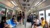 Commuters wear face masks and practice social distancing while onboard a subway on May 19, 2021. Zen Soo/AP