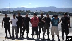 Guatemalan police escort suspected members of the Zetas drug cartel at the air force base in Guatemala City, March 8, 2012.