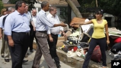 President Barack Obama walks with New Jersey Gov. Chris Christie in Wayne, N.J., Sunday, Sept. 4, 2011, as he tours flood damage caused by Hurricane Irene.