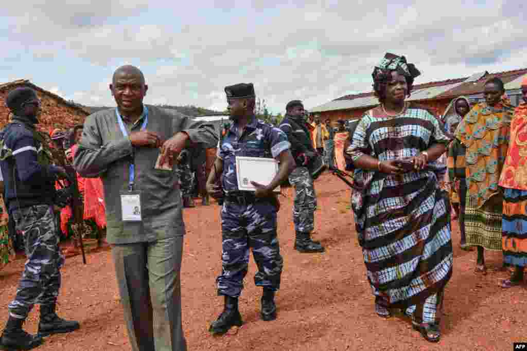 Le leader de l'opposition burundaise, Agathon Rwasa, arrive avec son épouse dans un bureau de vote à Ciri, dans le nord du Burundi, le 17 mai 2018.