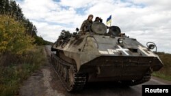 Ukrainians ride an armoured vehicle, amid Russia's attack on Ukraine, in Donesk region, Ukraine, October 3 2022. (REUTERS/Zohra Bensemra)