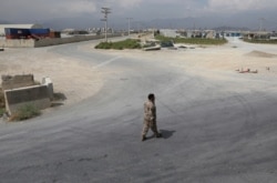 A member of the Afghan security forces walks in the sprawling Bagram air base after the American military departed, in Parwan province north of Kabul, Afghanistan, July 5, 2021.