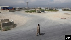 A member of the Afghan security forces walks in the sprawling Bagram air base after the American military departed, in Parwan province north of Kabul, Afghanistan, Monday, July 5, 2021. The U.S. left Afghanistan's Bagram Airfield after nearly 20…