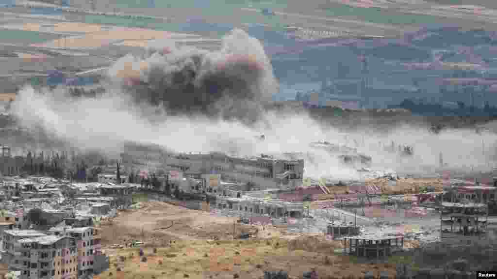 Smoke rises from the national hospital, after what activists said was shelling by warplanes loyal to Syria's President Bashar al-Assad in the town of Jisr al-Shughour, Idlib province, May 22, 2015.