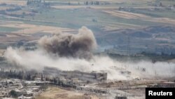 FILE - Smoke rises after what activists said was shelling by forces loyal to Syria's President Bashar al-Assad, in Idlib province, Syria, May 22, 2015.