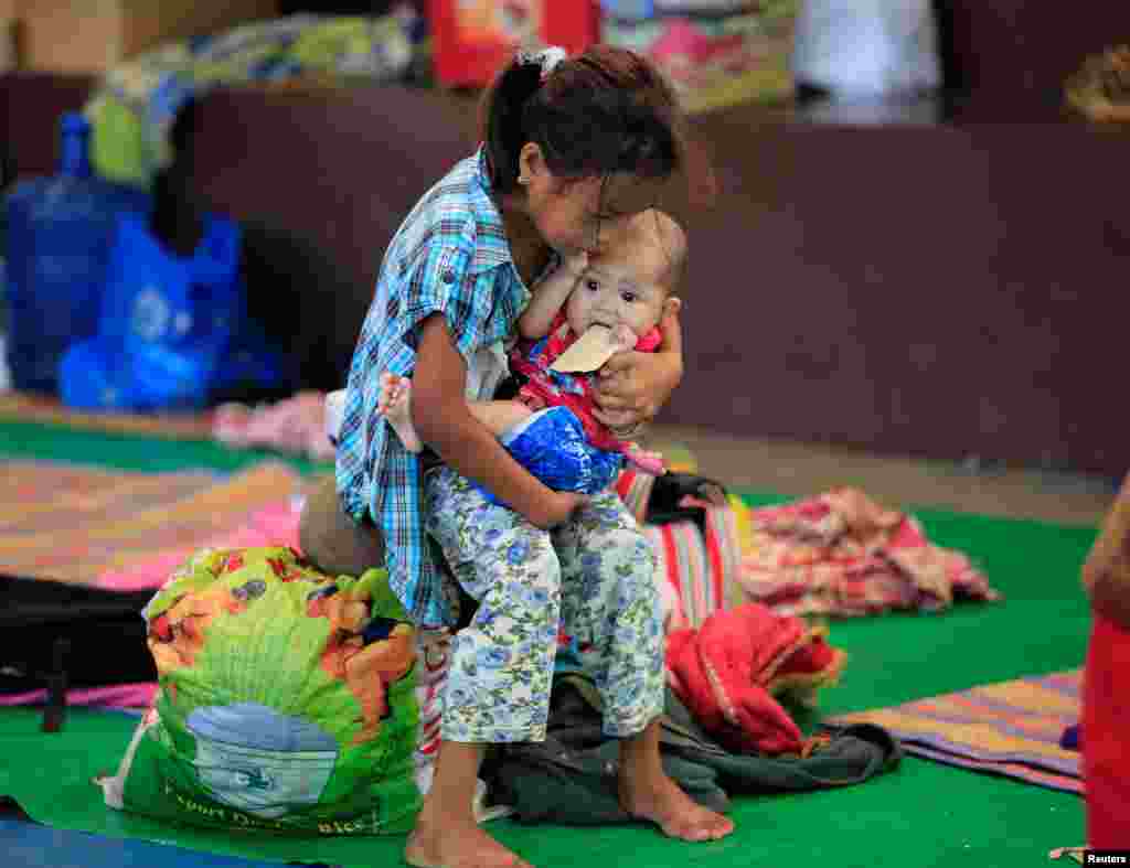 필리핀 남부에서 교전을 피해 대피소에 온 소녀가 아기를 보살피며 구호물품을 기다리고 있다.