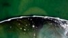 საჰაერო კამერით გადაღებული ფოტო, რომელიც მოტივტივე ბარიერებით გაჟონილი ნავთობის სანაპიროსკენ გავრცელების შეჩერებას ცდილობს. 4 ოქტომბერი, 2021 (AP Photo/Ringo H.W. Chiu)