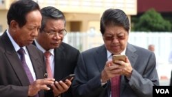 Senior Cambodian government officials are using their smart phones while awaiting the return of Cambodian Prime Minister Hun Sen from France at Phnom Penh International Airport, October 28, 2015. Government officials and state institutions have recently taken to Facebook to inform the public as the social media platform is becoming increasingly popular among Cambodian youth. (Hean Socheata/VOA Khmer) 