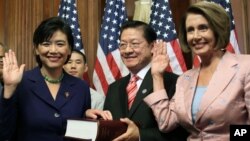 Rep. Judy Chu, D-Calif., left, re-enacts a swearing-in ceremony administered by House Speaker Nancy Pelosi July 16, 2009, in Washington. Chu's husband, Mike Eng, observes.