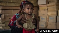 A Rohingya refugee mother holds her recovering baby who has received treatment for malnutrition at an Action Against Hunger clinic in Ukhiya, Bangladesh, April 18, 2018.