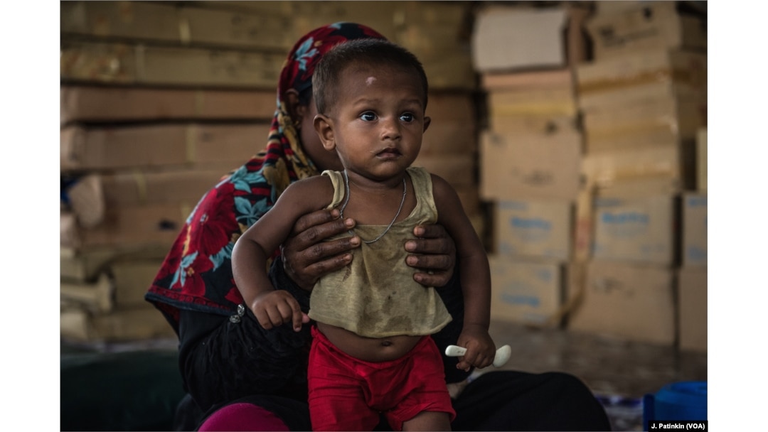 A Rohingya refugee mother holds her recovering baby who has received treatment for malnutrition at an Action Against Hunger clinic in Ukhiya, Bangladesh, April 18, 2018.