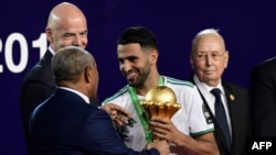 L'attaquant algérien Riyad Mahrez reçoit le trophée des mains du président de la Confédération africaine de football, Ahmad Ahmad, lors de la finale de la Coupe d'Afrique des Nations 2019 entre le Sénégal et l'Algérie au Caire le 19 juillet 2019.