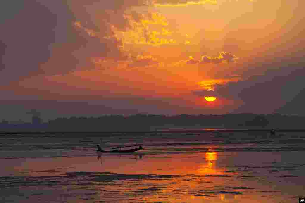 A Kashmiri man fishes from a traditional boat during sunset at the Dal Lake in Srinagar, India.