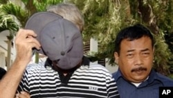 Australian Paul Francis Callahan, left, wanted in Australia and detained in Bali after being accused of child sex abuse, covers his face prior to his trial at a court in Denpasar (File Photo)