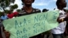 FILE - A protester holds a sign that reads in French "A+A=No. A+B=Yes. B+B=No" during an anti-gay demonstration in Port-au-Prince, Haiti.