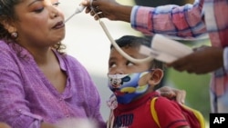 Una mujer que espera respuesta a su solicitud de asilo político en Estados Unidos es atendida por un médico voluntario en Matamoros, México. [Archivo]